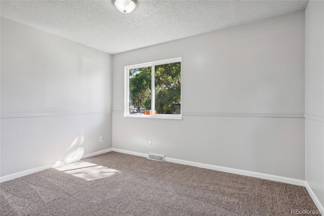 unfurnished room with carpet floors and a textured ceiling