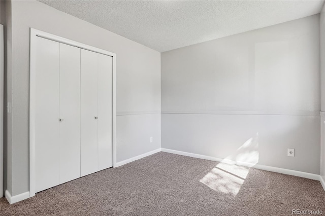 unfurnished bedroom with a textured ceiling, a closet, and carpet