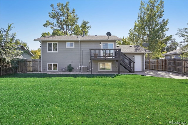 rear view of property featuring a deck, a yard, and central air condition unit