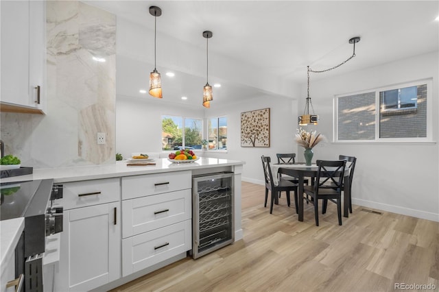 3541 Eudora St, Denver, CO 80207 - kitchen with beverage cooler, light wood-style floors, a peninsula, white cabinetry, and recessed lighting
