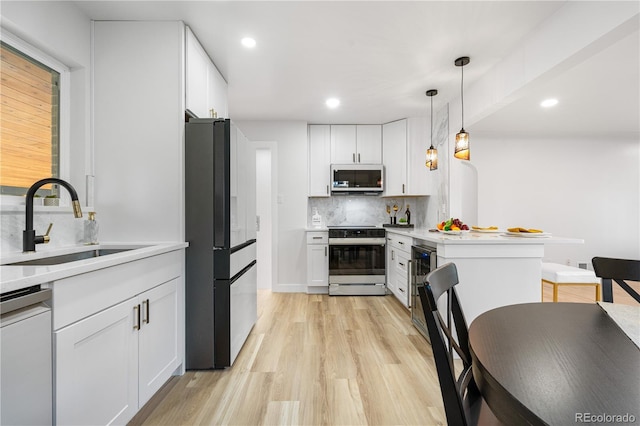 3541 Eudora St, Denver, CO 80207 - kitchen with appliances with stainless steel finishes, a sink, a peninsula, backsplash, and white cabinetry