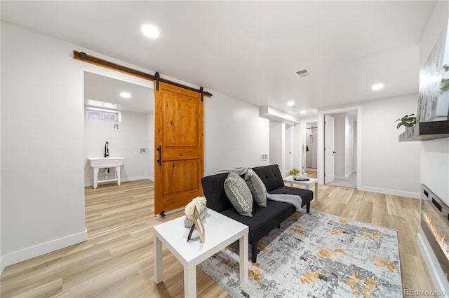 3541 Eudora St, Denver, CO 80207 - living area featuring a barn door, light wood-type flooring, recessed lighting, and baseboards