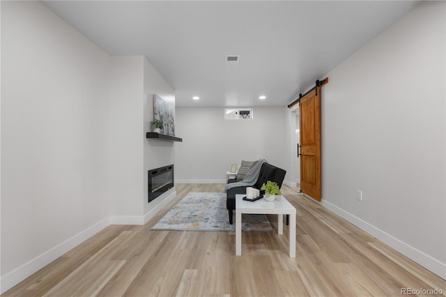 3541 Eudora St, Denver, CO 80207 - sitting room featuring recessed lighting, light wood-style flooring, baseboards, a glass covered fireplace, and a barn door
