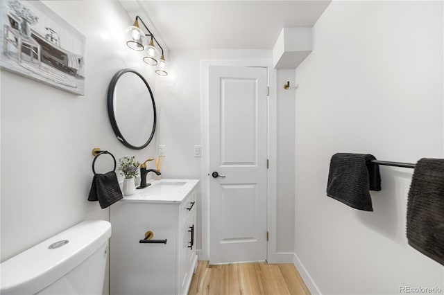 3541 Eudora St, Denver, CO 80207 - half bath with wood finished floors, vanity, toilet, and baseboards