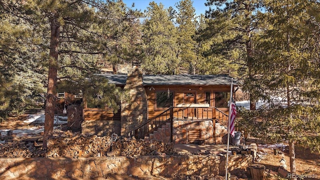 view of outbuilding featuring a forest view and stairs