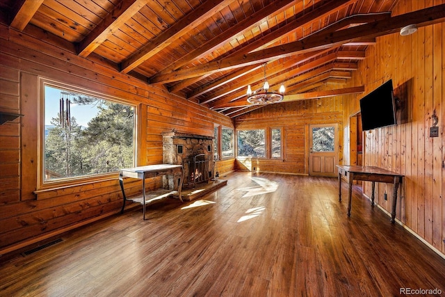 living room featuring wooden walls, visible vents, lofted ceiling with beams, wooden ceiling, and hardwood / wood-style floors