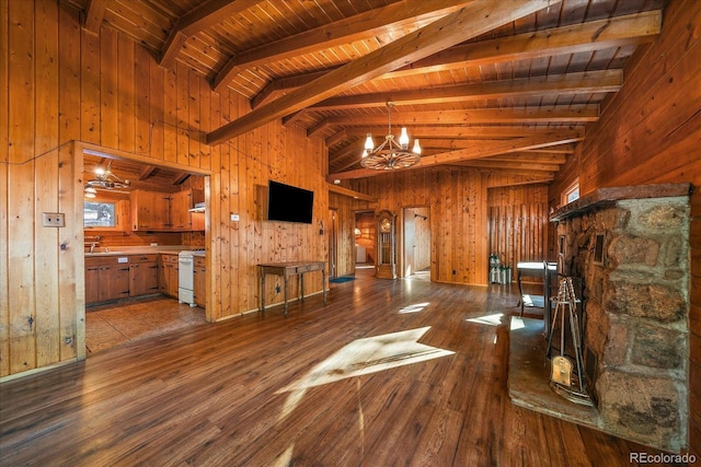 unfurnished living room with a chandelier, beamed ceiling, wooden walls, and hardwood / wood-style floors