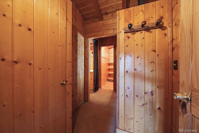 corridor with light carpet, wood ceiling, and wooden walls