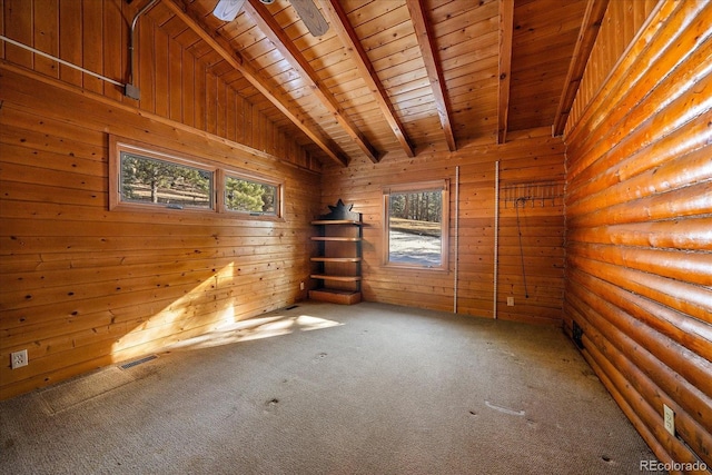 spare room featuring lofted ceiling with beams, carpet floors, wood walls, wood ceiling, and visible vents