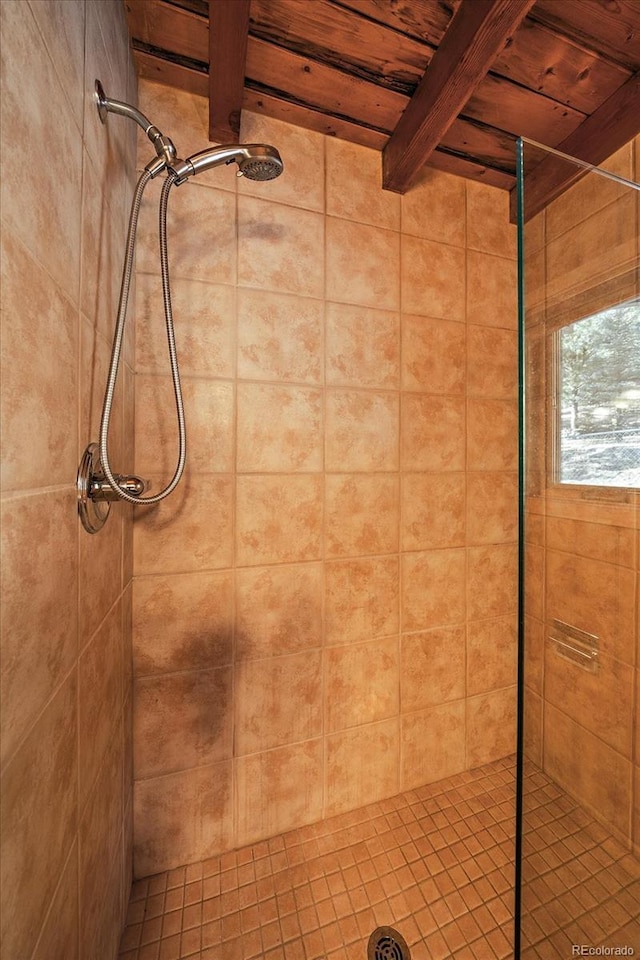 bathroom featuring wood ceiling, beam ceiling, and a tile shower