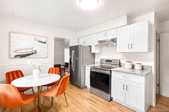 3054 S Raleigh St, Denver, CO 80236 - kitchen featuring appliances with stainless steel finishes, ventilation hood, light wood-type flooring, and white cabinetry