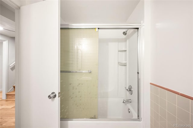 3054 S Raleigh St, Denver, CO 80236 - bathroom with shower / bath combination with glass door, tile walls, wood finished floors, and wainscoting
