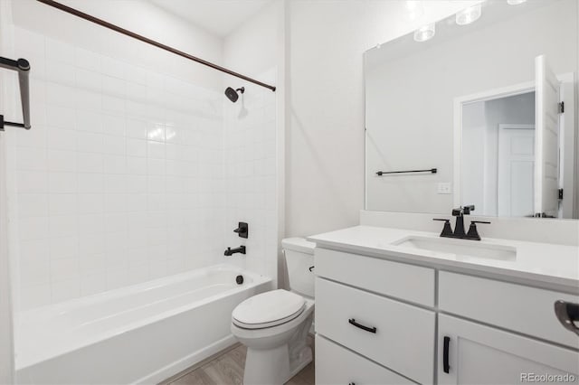 full bathroom with toilet, vanity, and tiled shower / bath