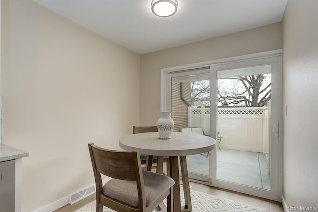 dining area with visible vents, baseboards, and light wood-style floors