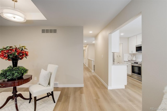 hallway featuring visible vents, light wood-style flooring, recessed lighting, and baseboards