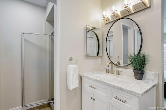 bathroom featuring a notable chandelier, vanity, and a stall shower