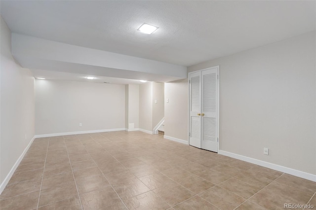 finished below grade area featuring stairway and baseboards