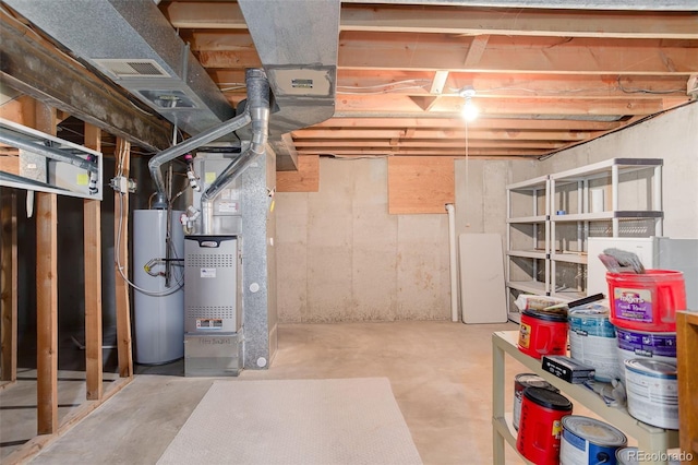 unfinished below grade area featuring water heater and heating unit