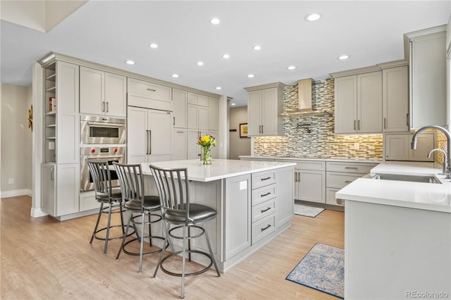 11465 W Atlantic Ave, Lakewood, CO 80227 - kitchen featuring wall chimney exhaust hood, a sink, a center island, a kitchen bar, and recessed lighting