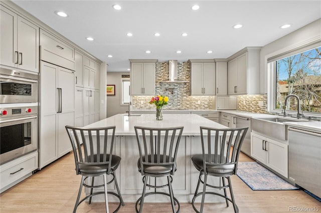 11465 W Atlantic Ave, Lakewood, CO 80227 - kitchen featuring stainless steel appliances, wall chimney range hood, a sink, tasteful backsplash, and recessed lighting