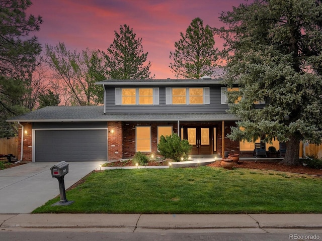 5845 W Portland Dr, Littleton, CO 80128 - view of front facade featuring concrete driveway, a garage, a lawn, covered porch, and brick siding