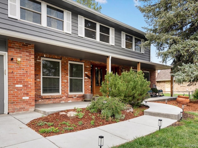 5845 W Portland Dr, Littleton, CO 80128 - view of front of house with covered porch and brick siding