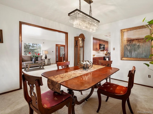 5845 W Portland Dr, Littleton, CO 80128 - dining space with light carpet, baseboards, and a chandelier