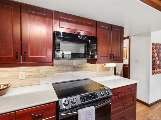 5845 W Portland Dr, Littleton, CO 80128 - kitchen featuring electric range, black microwave, and reddish brown cabinets
