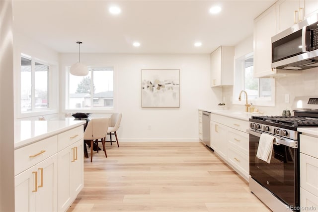 4395 Newland St, Wheat Ridge, CO 80033 - kitchen with stainless steel appliances, a sink, healthy amount of natural light, light countertops, and recessed lighting