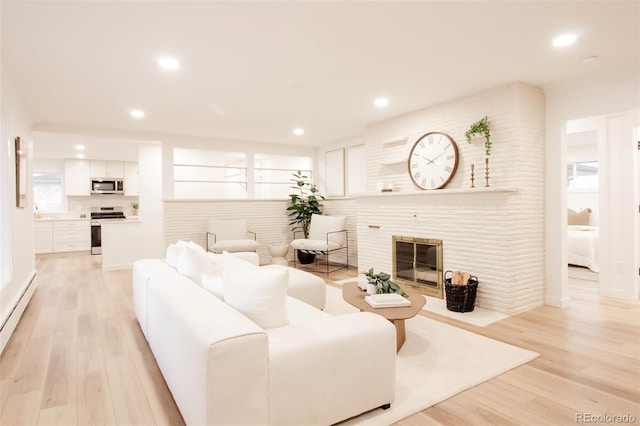 4395 Newland St, Wheat Ridge, CO 80033 - living area featuring light wood-style flooring, recessed lighting, a large fireplace, and plenty of natural light