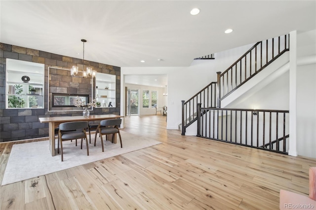 dining space with a chandelier, wood finished floors, stairs, and recessed lighting