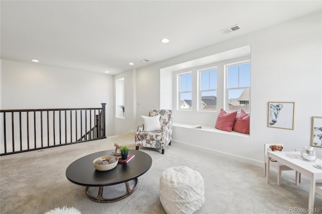 sitting room featuring recessed lighting, carpet floors, visible vents, and an upstairs landing