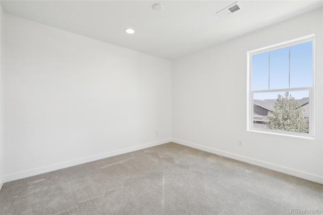 carpeted empty room with baseboards, visible vents, and recessed lighting