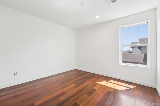 empty room with wood-type flooring, visible vents, baseboards, and recessed lighting