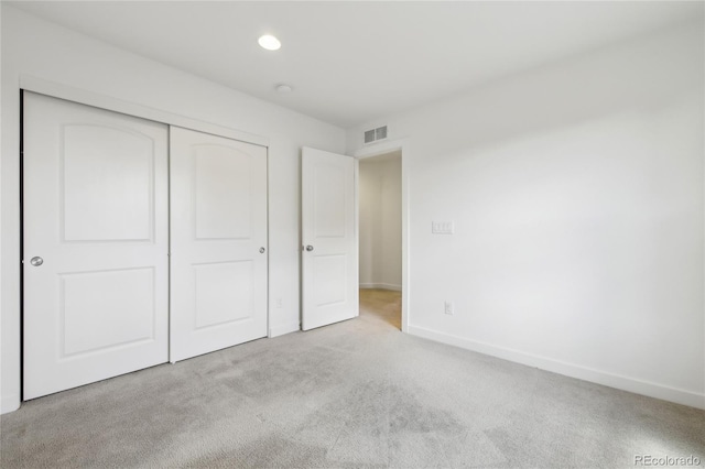 unfurnished bedroom featuring a closet, carpet, baseboards, visible vents, and recessed lighting