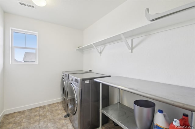 laundry area featuring separate washer and dryer, baseboards, visible vents, and laundry area