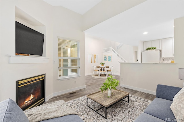 2017 N Fork Dr, Lafayette, CO 80026 - living area with stairs, a glass covered fireplace, light wood-style flooring, baseboards, and recessed lighting