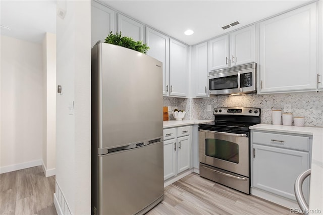 2017 N Fork Dr, Lafayette, CO 80026 - kitchen with stainless steel appliances, light wood finished floors, light countertops, tasteful backsplash, and white cabinets