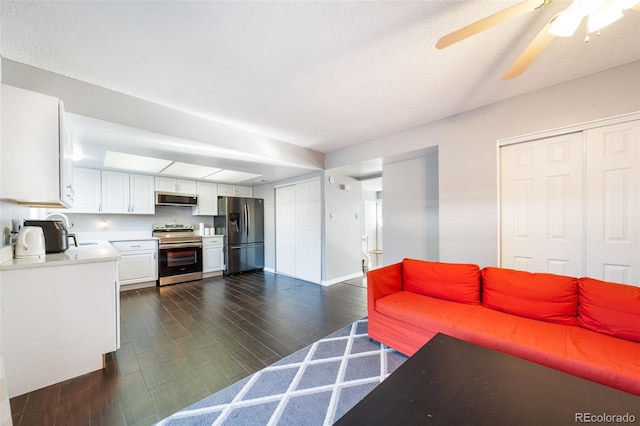 living room featuring a textured ceiling, ceiling fan, and dark hardwood / wood-style floors