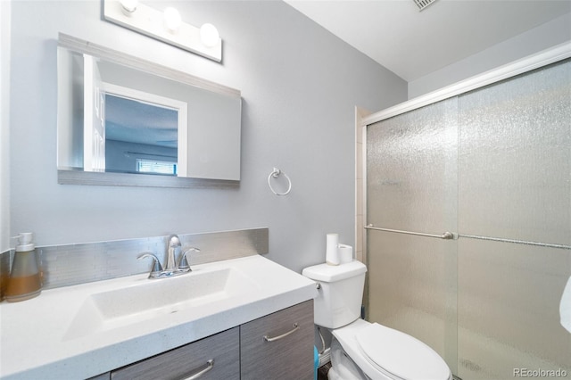 bathroom with vanity, toilet, and walk in shower