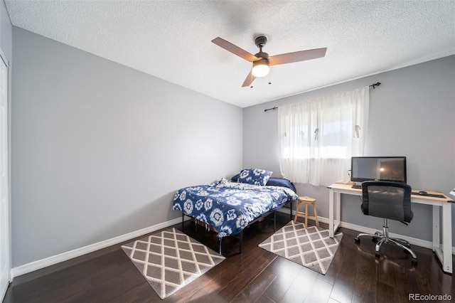 bedroom with ceiling fan, hardwood / wood-style flooring, and a textured ceiling