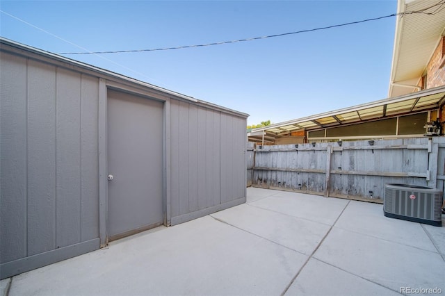 view of patio / terrace with central AC and an outbuilding