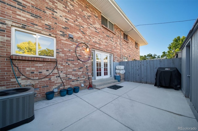 view of patio featuring cooling unit, a grill, and french doors