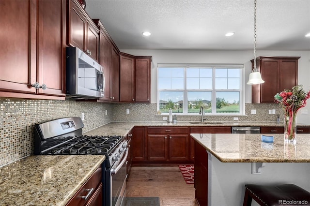 27029 E Irish Pl, Aurora, CO 80016 - kitchen with stainless steel appliances, dark wood finished floors, light stone countertops, backsplash, and recessed lighting