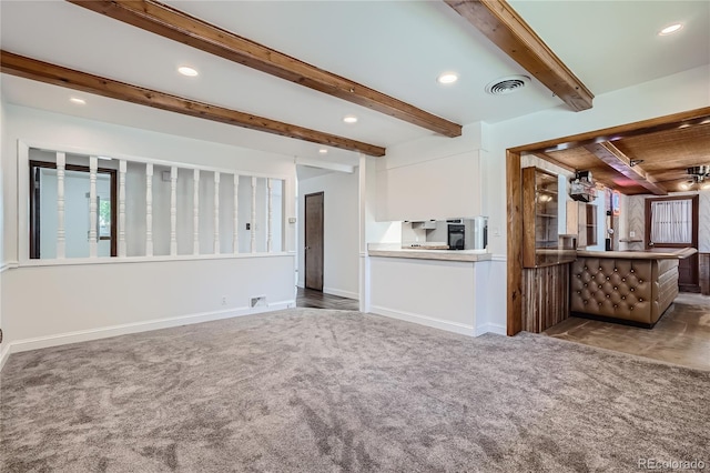 unfurnished living room featuring carpet flooring and beamed ceiling