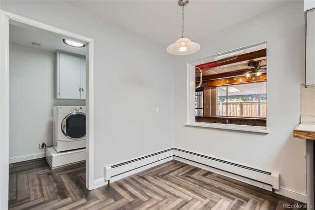 unfurnished dining area featuring beamed ceiling, dark parquet floors, a baseboard heating unit, and washer / dryer