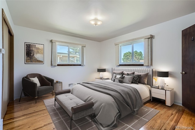 bedroom with multiple windows and wood-type flooring