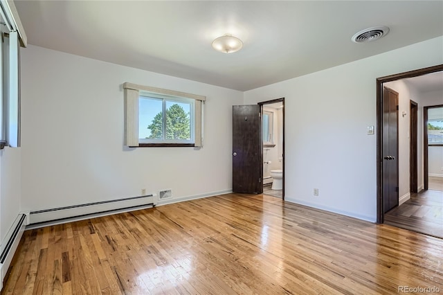 unfurnished bedroom with a baseboard radiator, light wood-type flooring, and ensuite bathroom