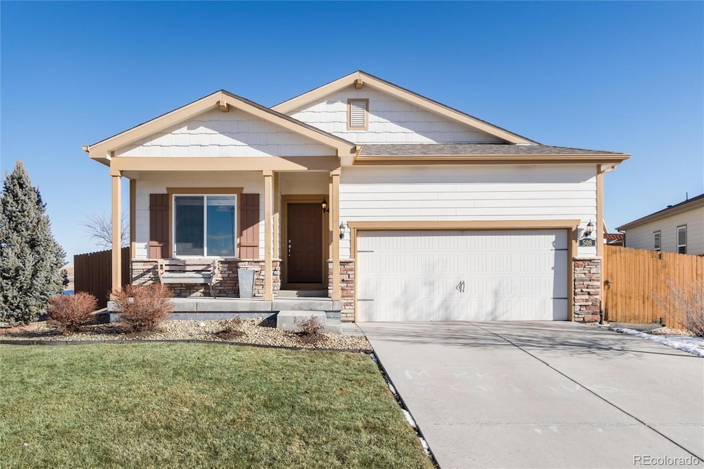 craftsman-style house with covered porch, a front lawn, and a garage