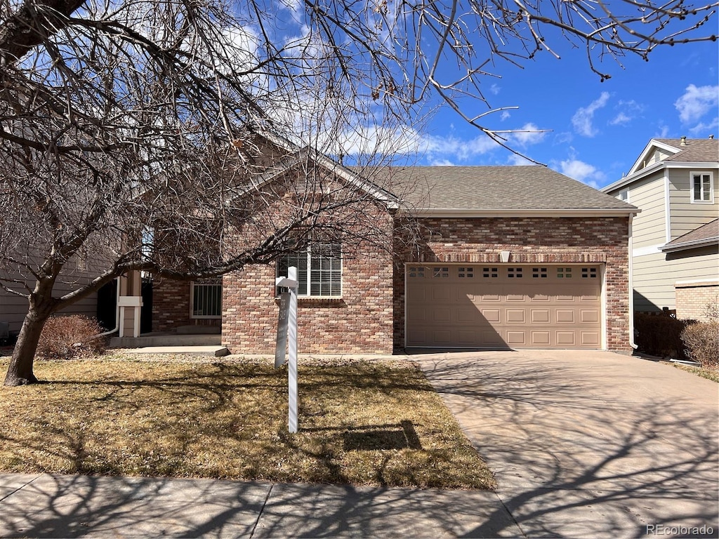 single story home with brick siding, concrete driveway, a garage, and a shingled roof